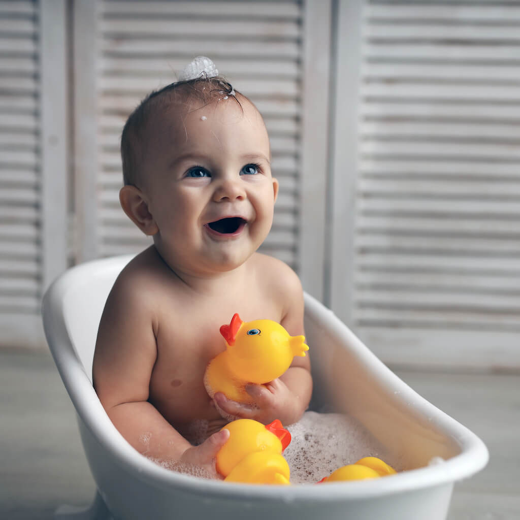 baby-11-months-is-bathing-white-baby-bath-with-rubber-ducklingsedit